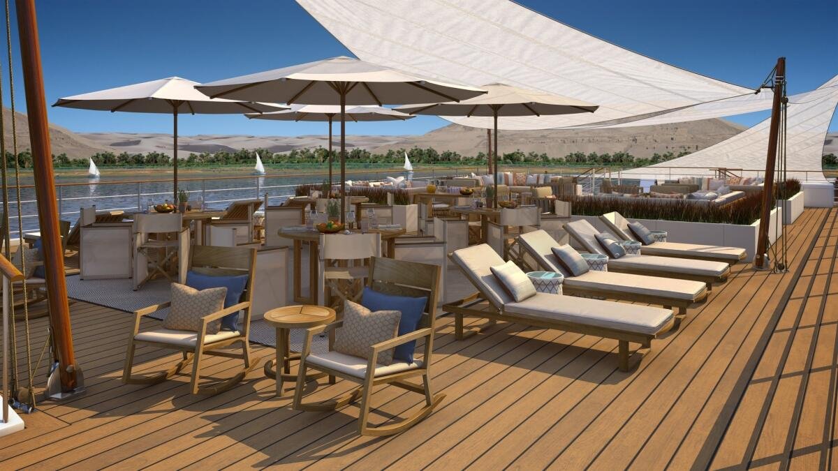 Luxury river cruise deck with sailboats and desert landscape