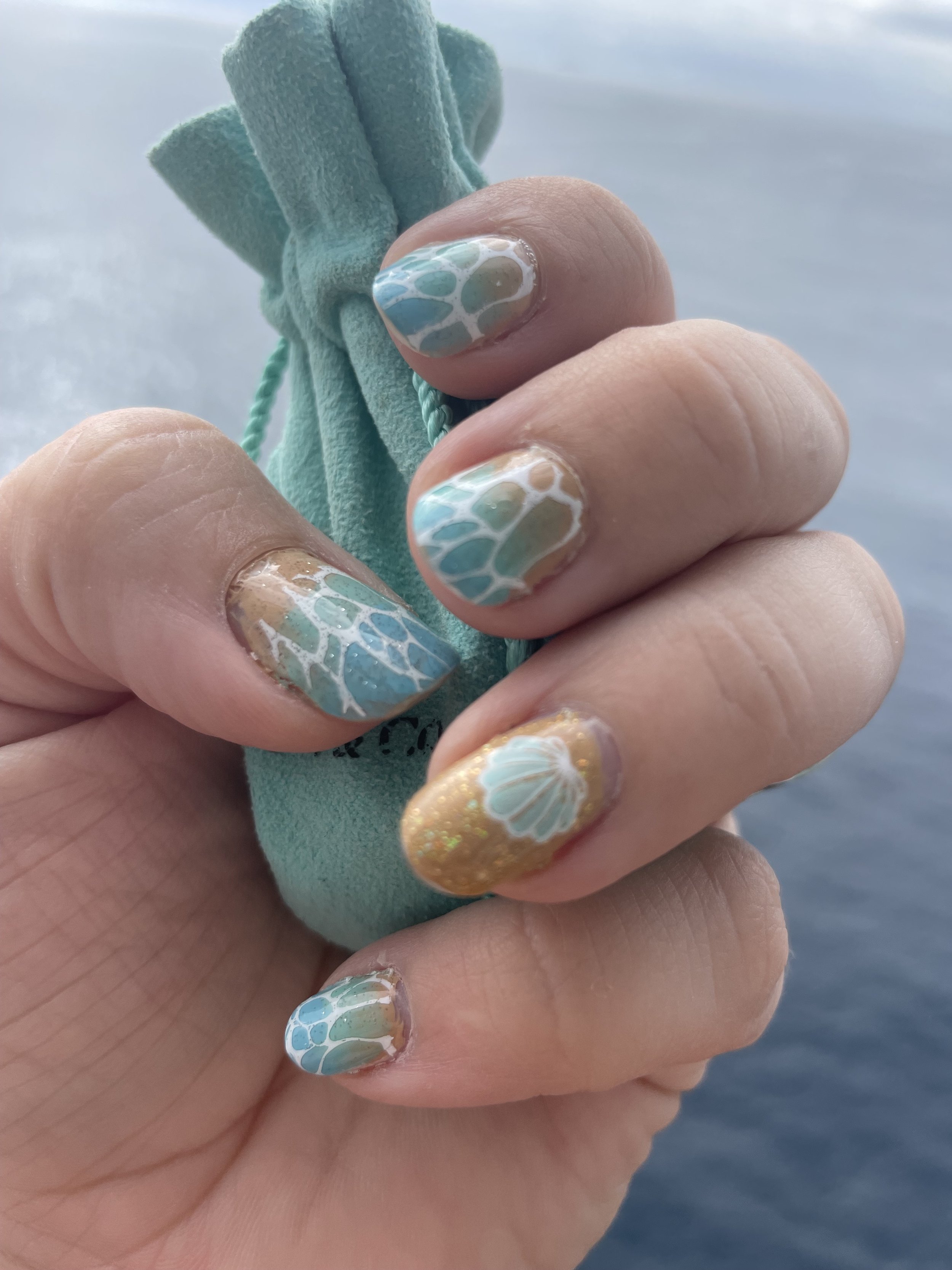 Ocean-themed seashell nail art with coastal design elements