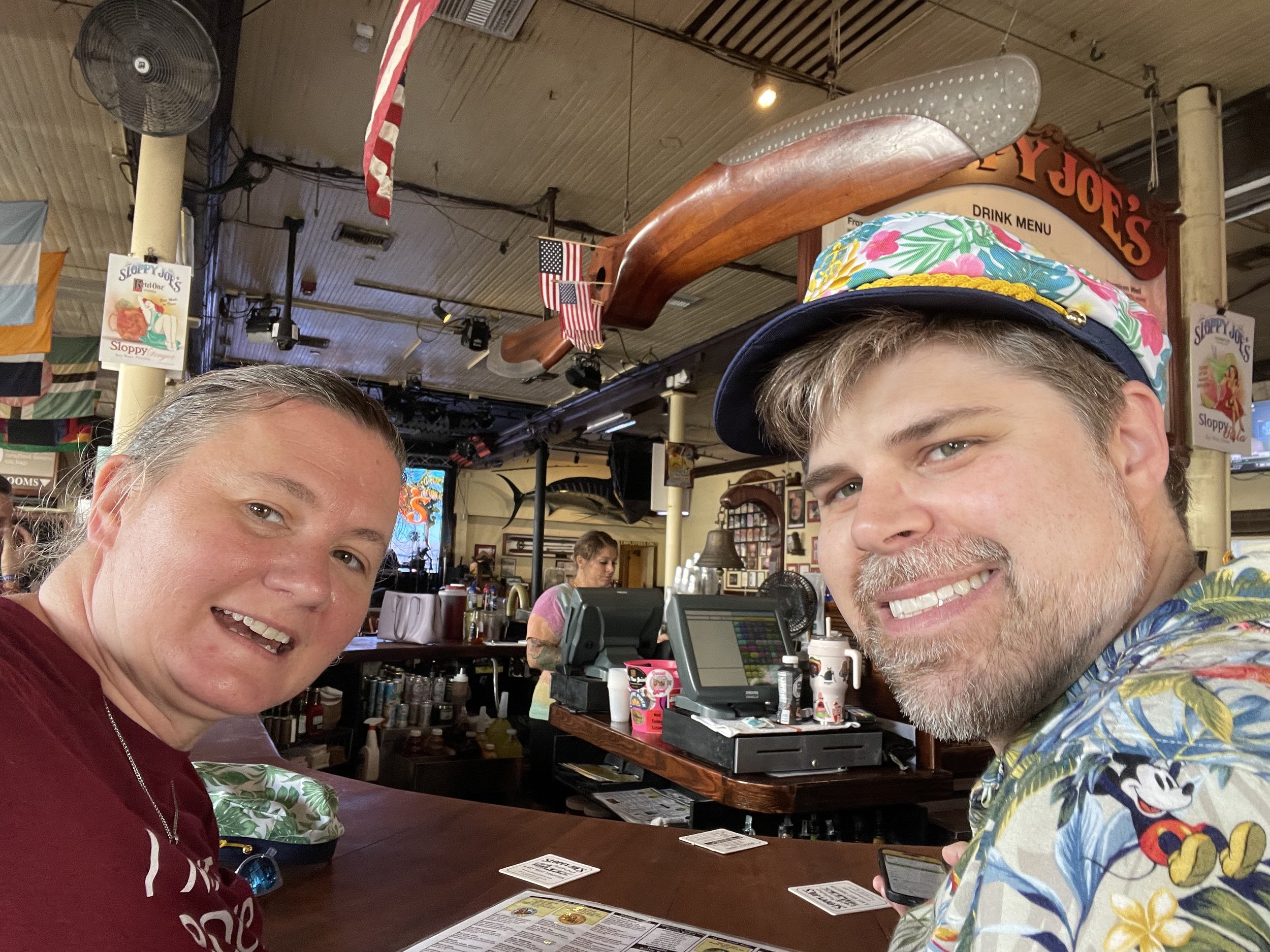 Two people smiling at casual restaurant with large decorative fish