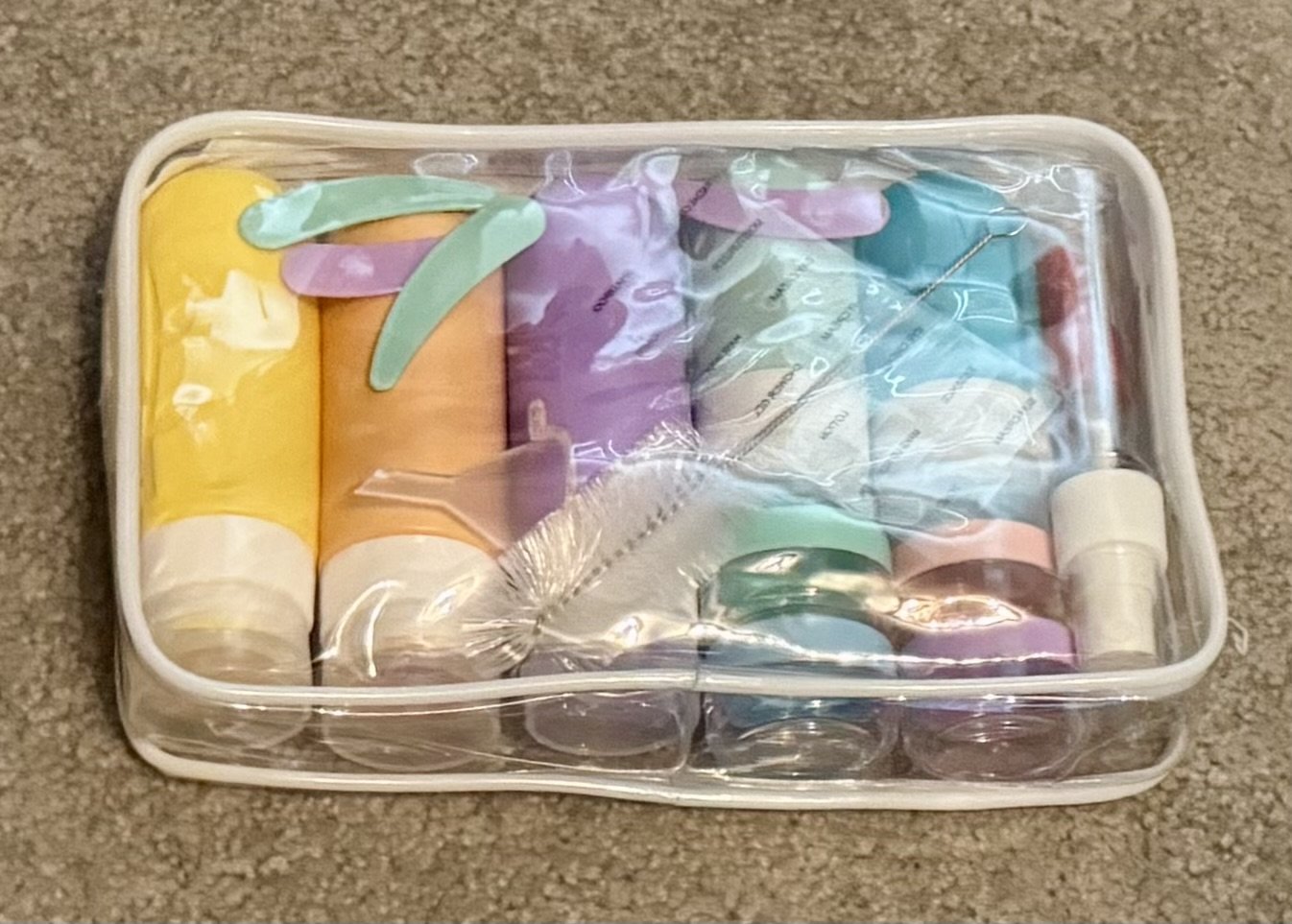 Travel toiletries and skincare products organized in a clear plastic storage container for cruise packing.