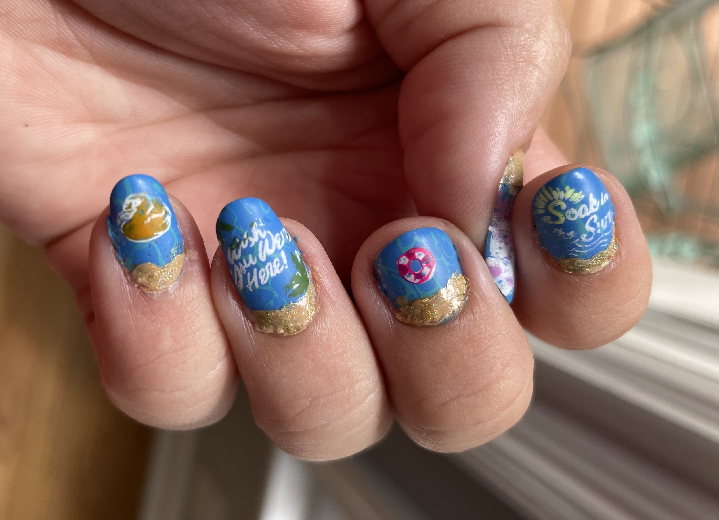 Cruise-themed nail art with blue and gold glitter design